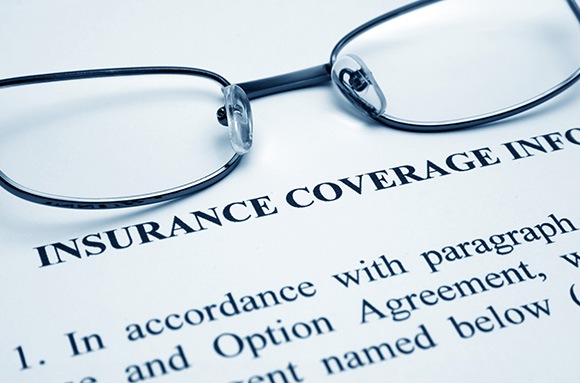 Dark wire-framed glasses sitting on “Insurance Coverage Info”