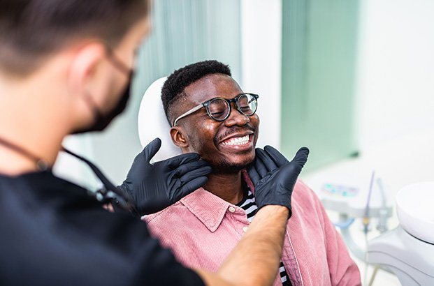 Dentist looking at smiling patient's teeth