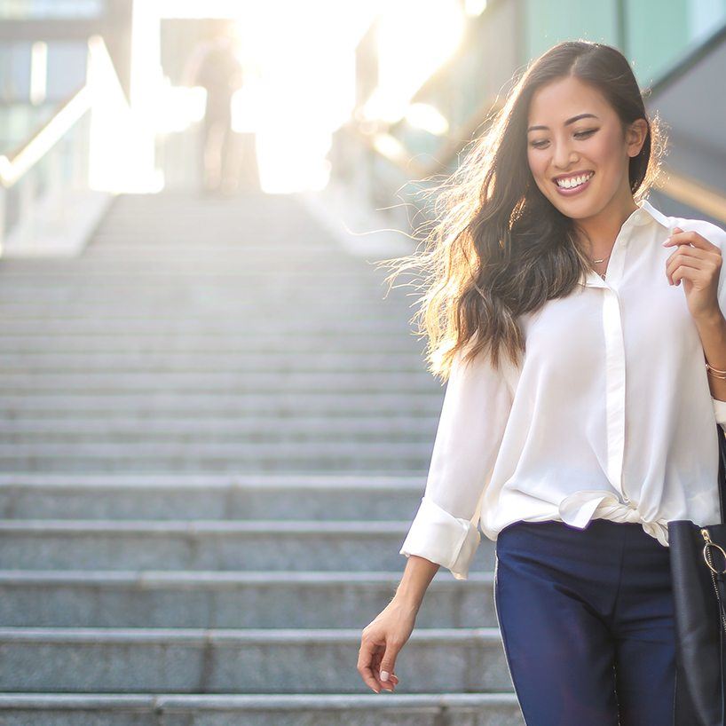 Woman smiling while walking down outdoor staircase