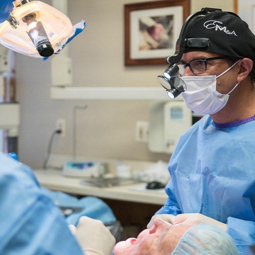 Dentist wearing personal protective equipment and dental binoculars